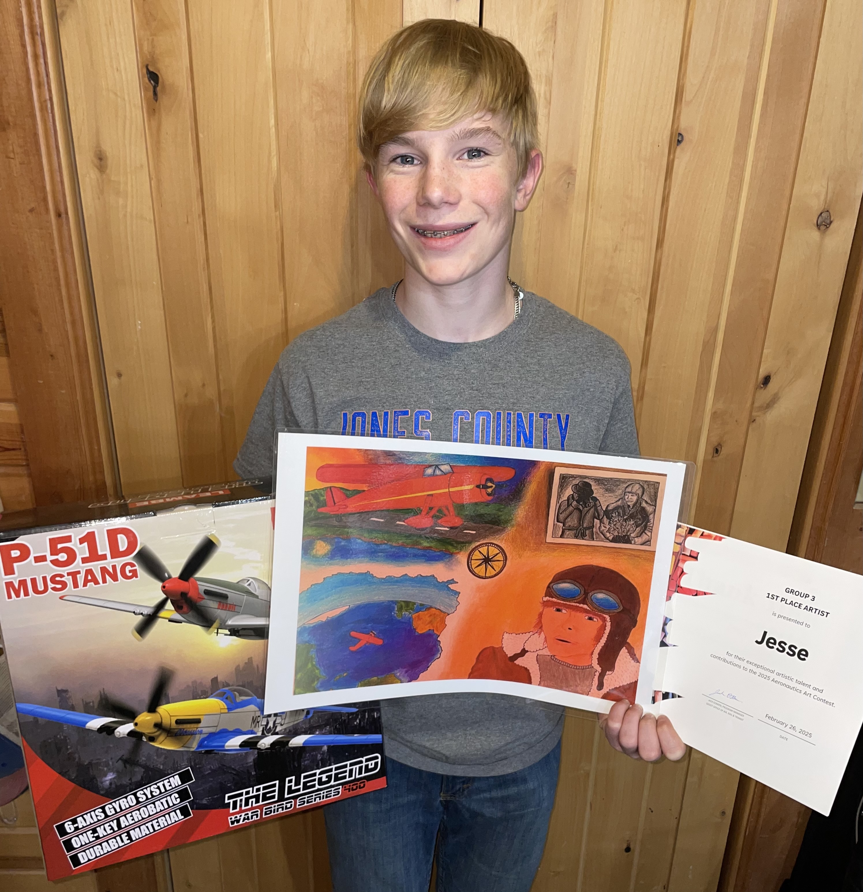 SDDOT 2025 Aeronautics Art Contest Winner - Jesse Schoon Murdo, S.D. holding his winning art and prize.